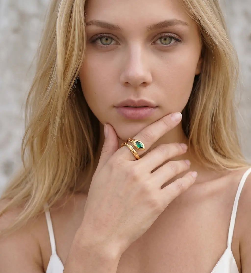 Aurora – Goldener Ring im Schlangen Design mit grünem Kristallstein getragen an der Hand von René Rose Jewelry
