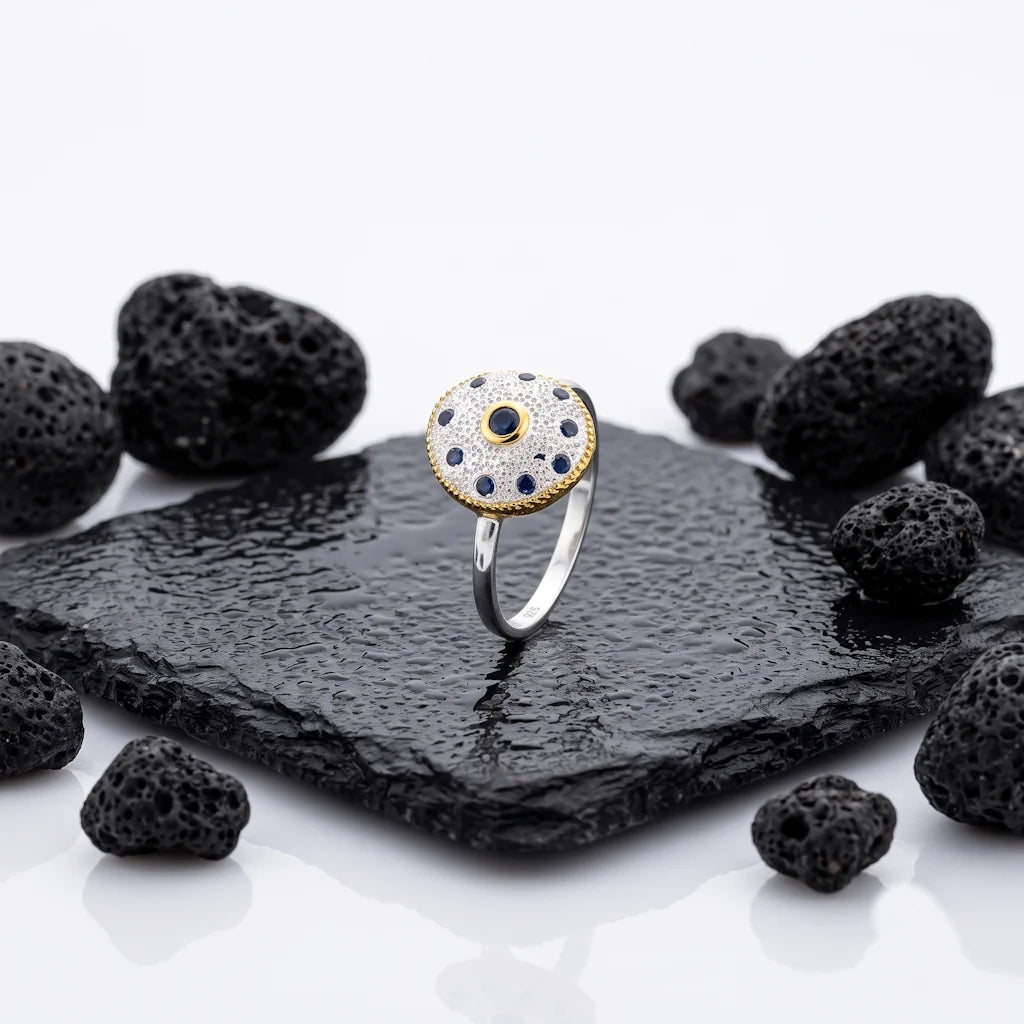 CERIDWEN AMULET – Exklusiver Medaillon Ring mit blauem Saphir und Kristallen aus 925 Sterling Silber präsentiert auf schwarzem Lavastein von René Rose Jewelry