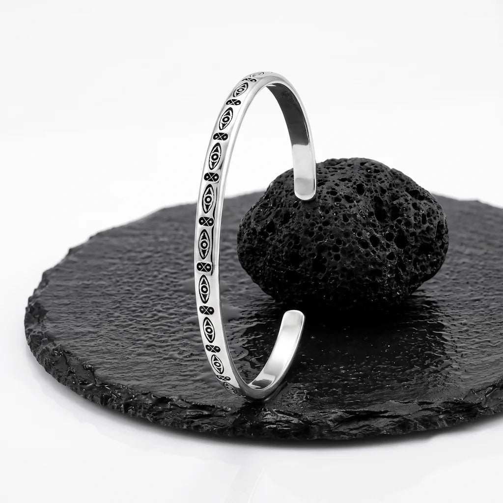 CERIDWEN EYE – Breiter Manschetten Armreif mit Auge Motiv aus massivem 925 Sterling Silber präsentiert auf schwarzem Lavastein von René Rose Jewelry