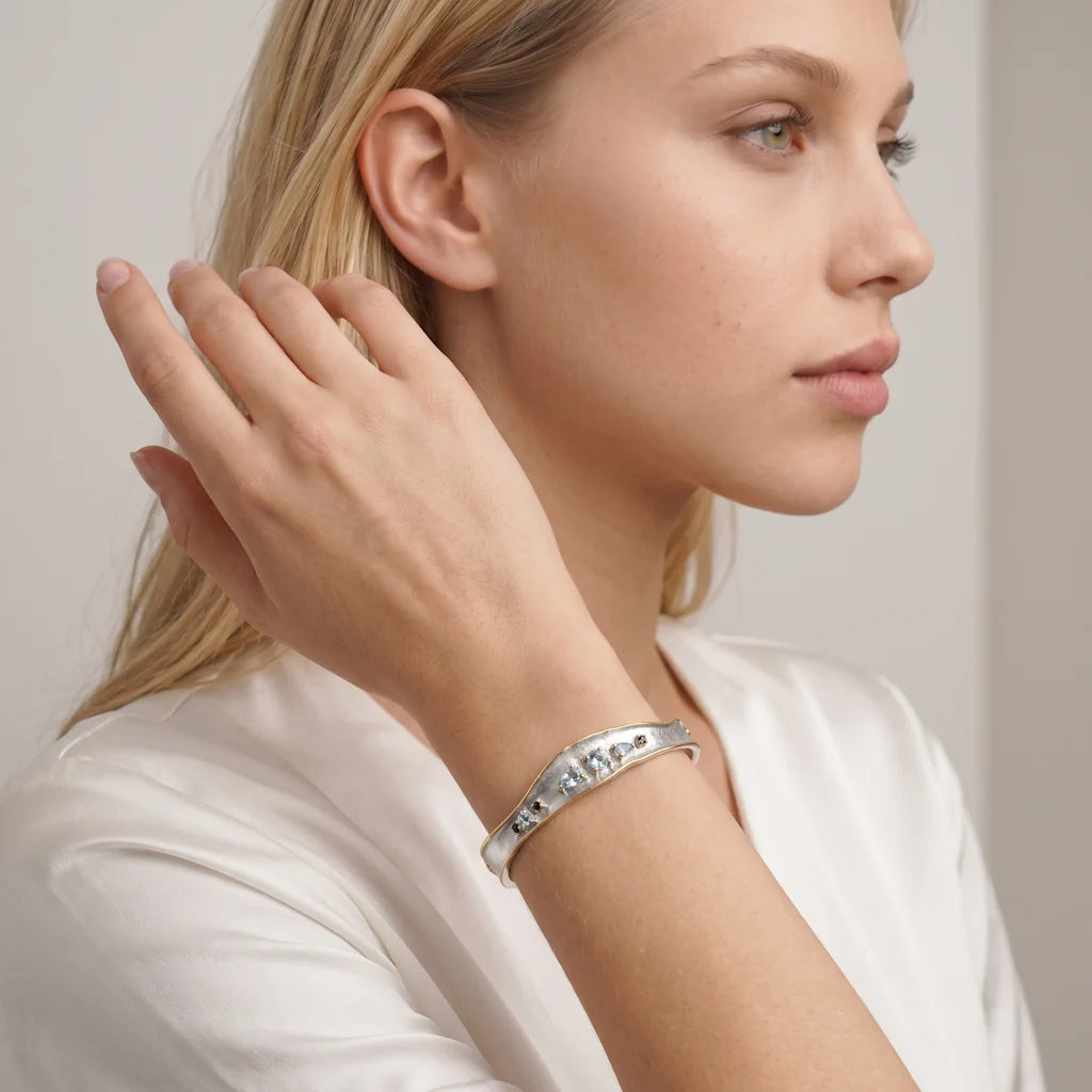 ARTEMIS WAVE – Opulentes silbernes Cuff Armband mit echten Edelsteinen im maritimen Ozean Look getragen am Handgelenk von René Rose Jewelry