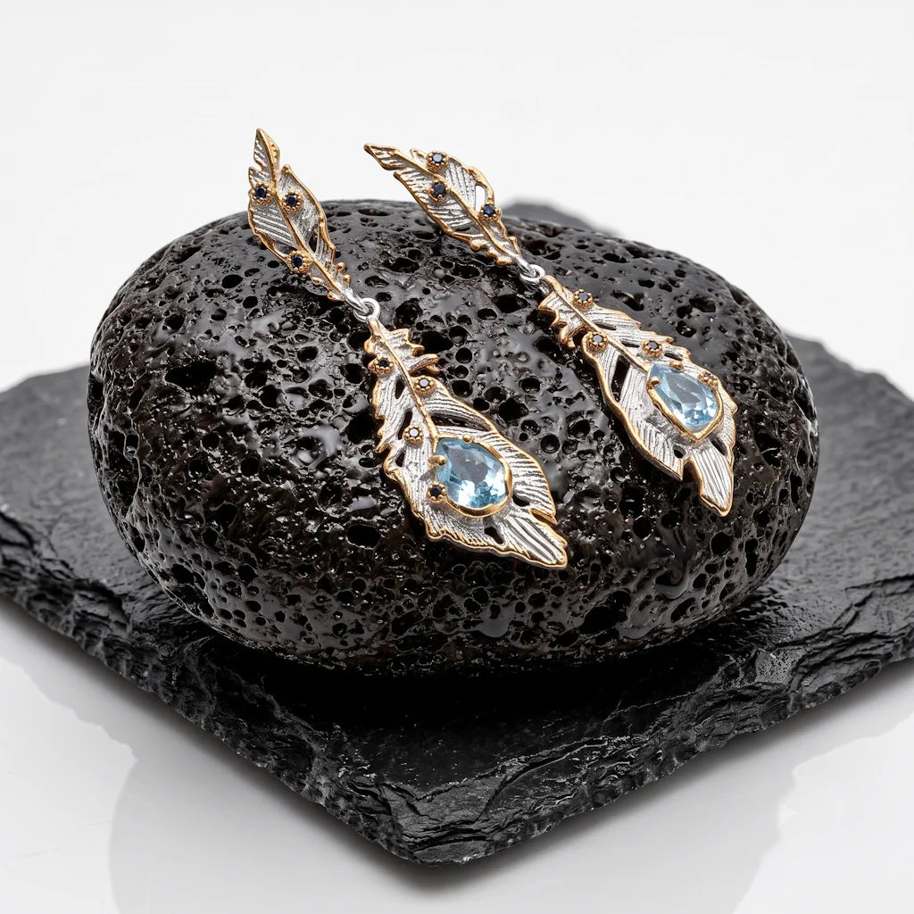 AURA FEATHER – Exklusive Bicolor Feder Ohrhänger mit blauem Topas und Saphir aus 925 Sterling Silber präsentiert auf schwarzem Lavastein von René Rose Jewelry