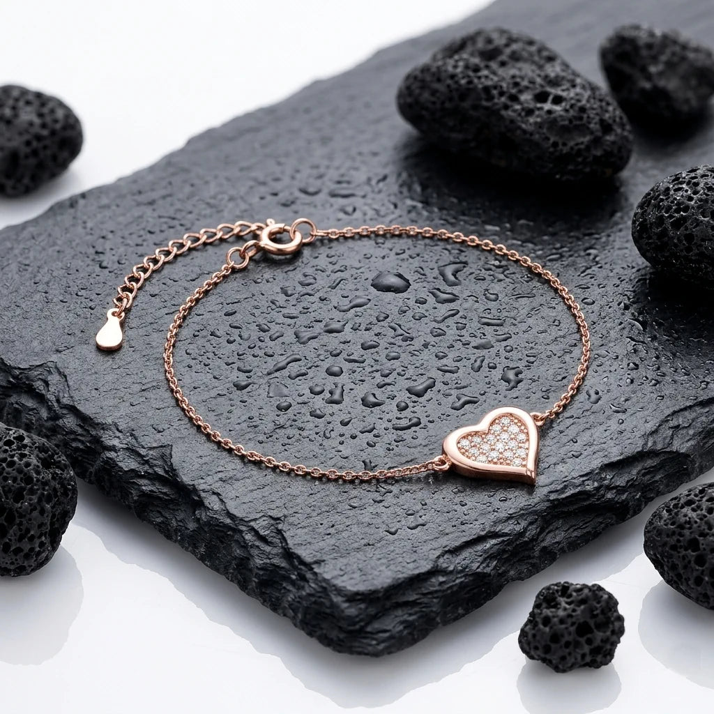 ALINA PAVÉ – Filigranes Herz Armband mit funkelnden Zirkonia aus 14k roségoldvergoldetem 925 Sterling Silber präsentiert auf dunkler Schieferplatte von René Rose Jewelry