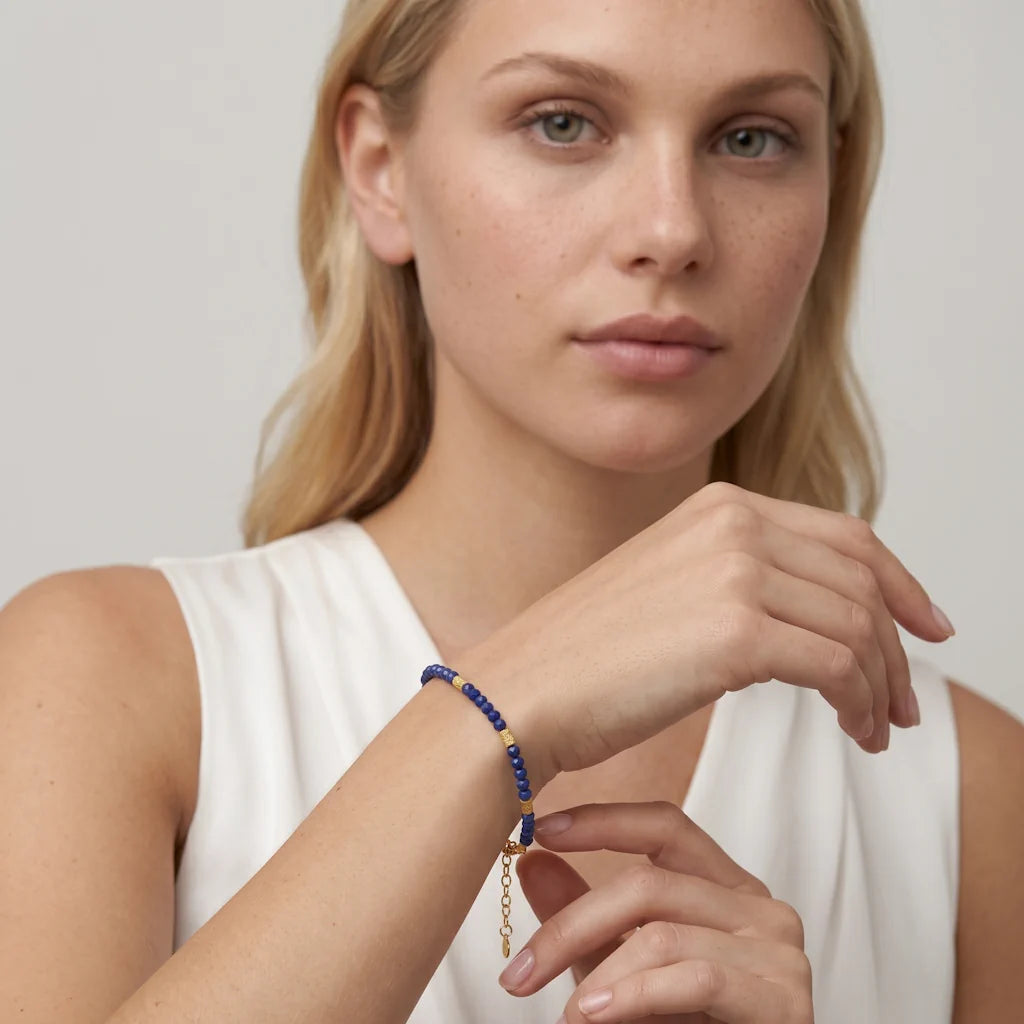 LAGERTHA LAPIS – Elegantes goldenes Station Armband mit blauem Naturstein getragen am Handgelenk von René Rose Jewelry
