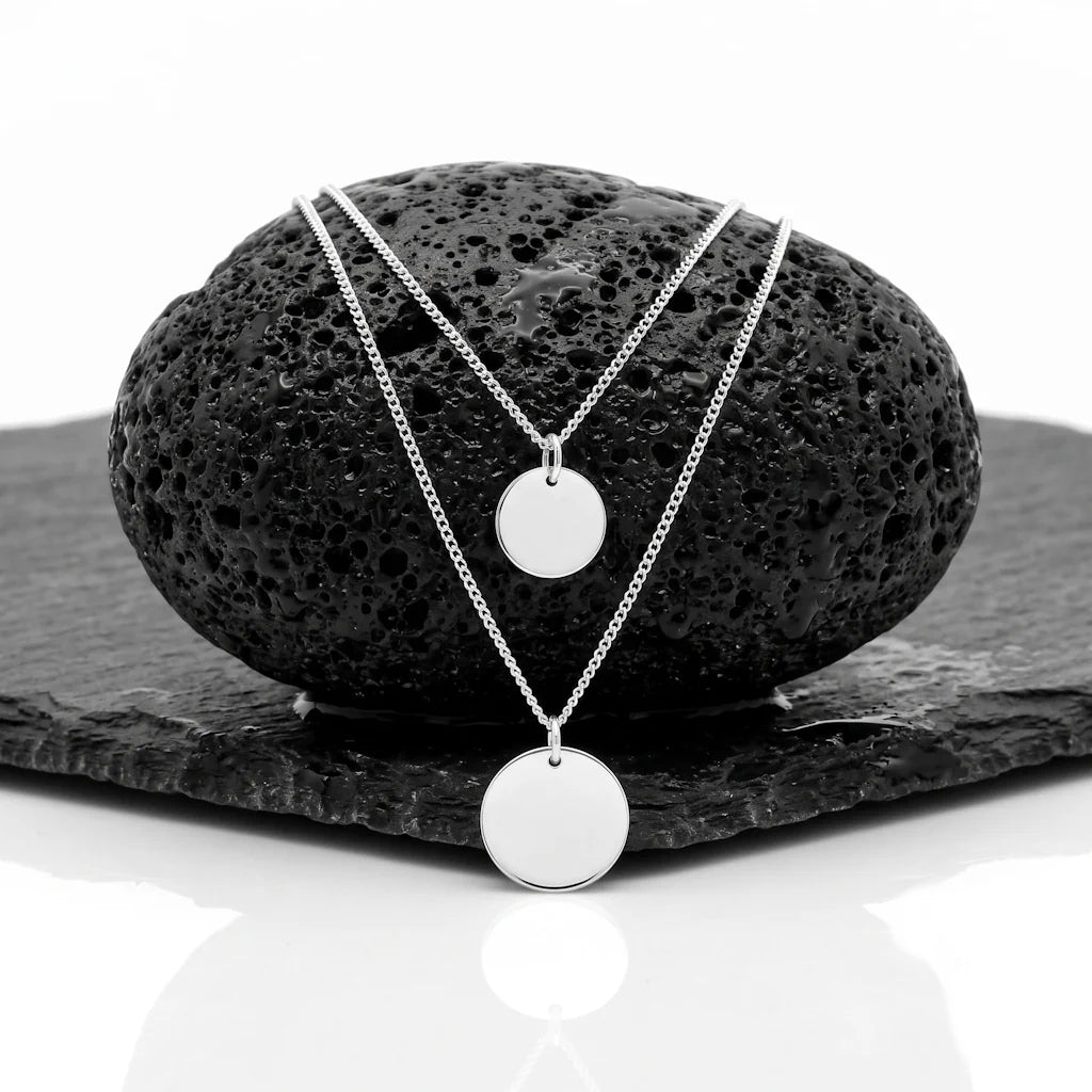 LUNA LAYER – Zweireihige Layering Kette mit Medaillon aus 925 Sterling Silber präsentiert auf dunkler Schieferplatte von René Rose Jewelry