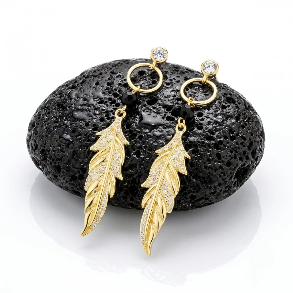 PIUMA BLACK AURA – Lange Boho Ohrhänger mit schwarzen Elementen aus vergoldetem 925 Sterling Silber präsentiert auf schwarzem Lavastein von René Rose Jewelry