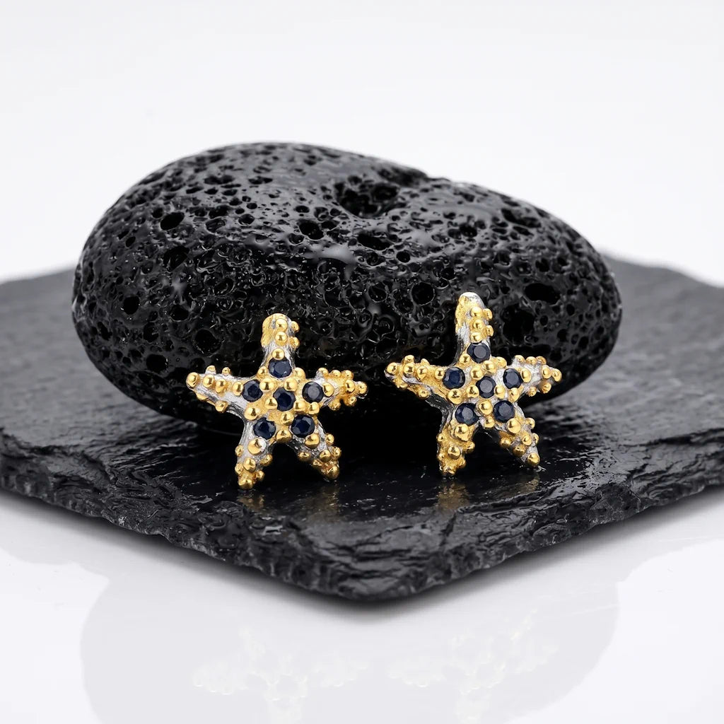 STELLA MARINA – Exklusive Saphir Ohrringe im maritimen Seestern Design aus 925 Sterling Silber präsentiert auf schwarzem Lavastein von René Rose Jewelry