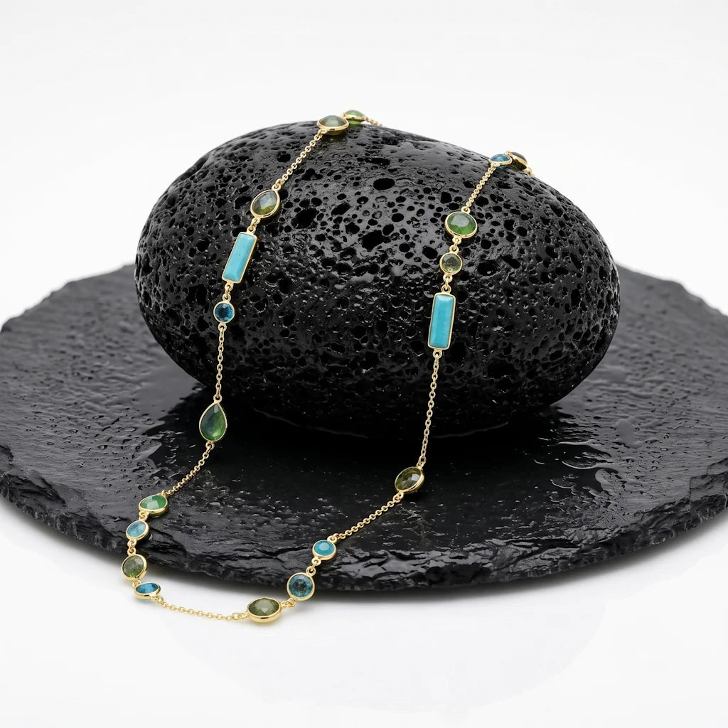 LAGERTHA RIVIERA – Extralange goldene Edelstein Kette mit Aquachalcedon und Jade aus 18k vergoldetem 925 Sterling Silber präsentiert auf schwarzem Lavastein von René Rose Jewelry