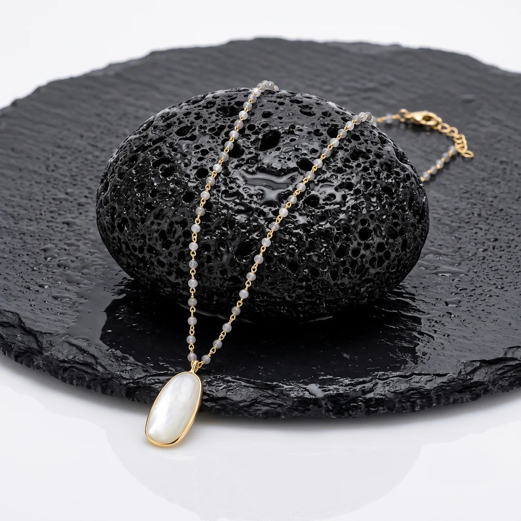 OANA MYSTIQUE – Extralange goldene Edelstein Kette mit Labradorit und Mondstein aus 18k vergoldetem 925 Sterling Silber präsentiert auf schwarzem Lavastein von René Rose Jewelry
