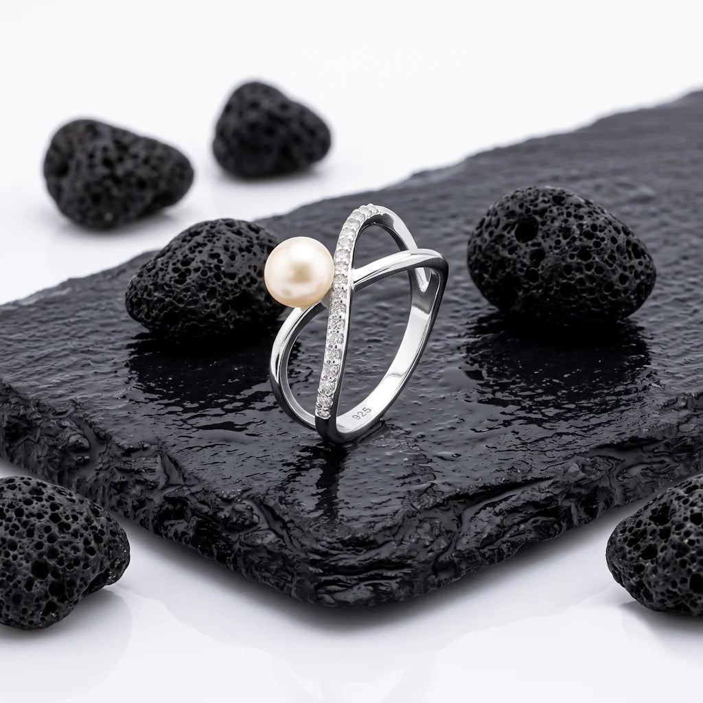 MAYA INFINITY – Skulpturaler Infinity Ring mit Perle aus 925 Sterling Silber präsentiert auf schwarzem Lavastein von René Rose Jewelry