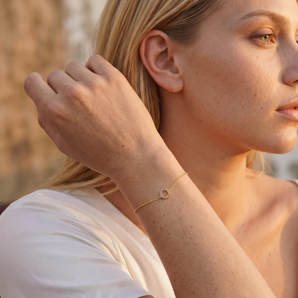 Model trägt das René Rose Jewelry AZURÉA Designer-Armband aus 925 Sterling Silber mit Kreis-Anhänger, blauen und lilafarbenen Zirkonia sowie hochwertiger 14 Karat Gelbgold-Vergoldung.