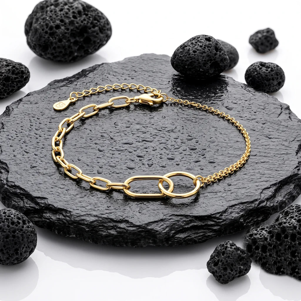 René Rose Jewelry ÉLIANE luxuriöses Designer-Armband aus 925 Sterling Silber mit Kreis, Oval, doppelreihiger Gliederkette und 14 Karat Gelbgold-Vergoldung, stilvoll auf Lavastein und Schieferplatten präsentiert.
