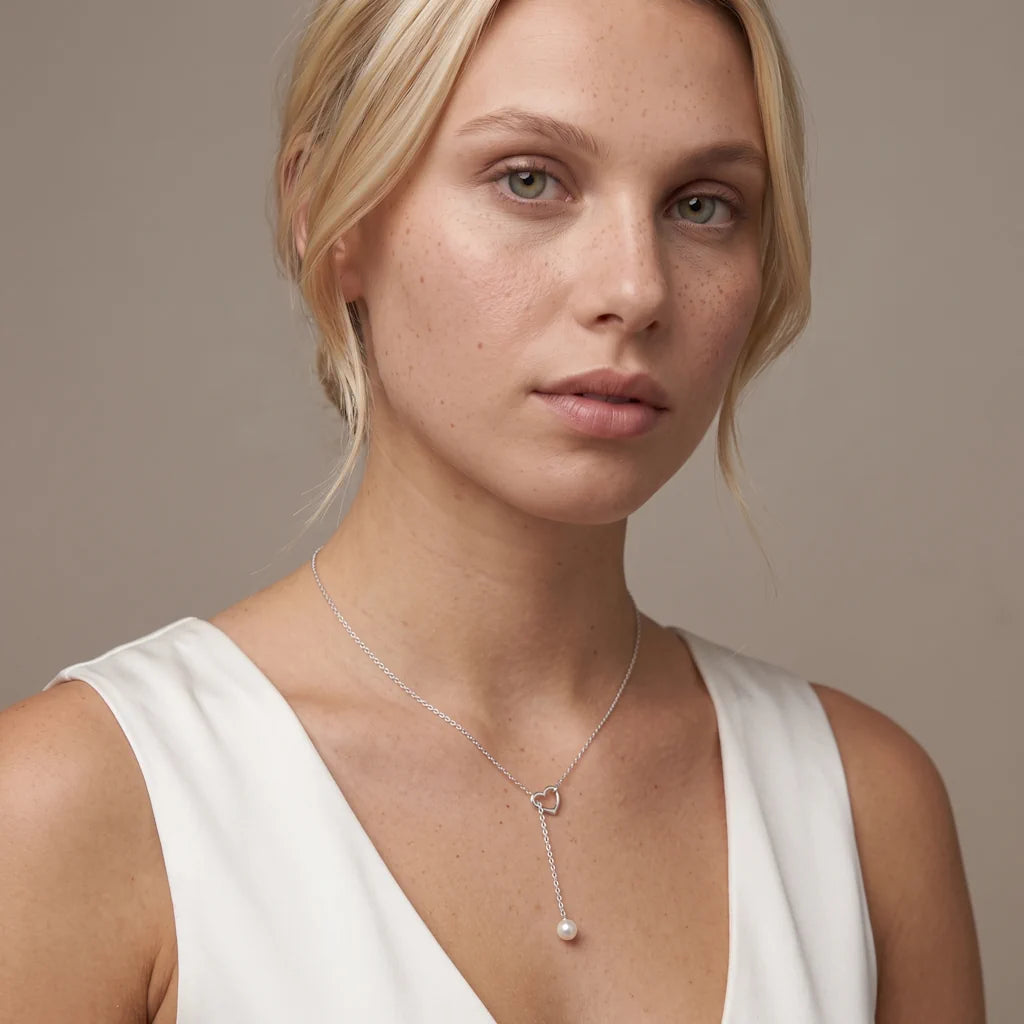 ANNIKA AMOUR PERLA – Elegantes silbernes Lariat Collier im romantischen Herz Design mit Perle getragen am Dekolleté von René Rose Jewelry