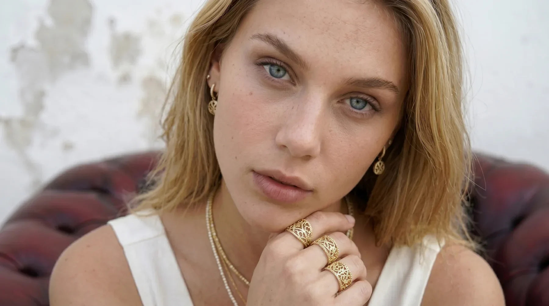Elegante Frau mit hochwertigem Goldschmuck und Ringen der High-Class-Marke René Rose Jewelry.