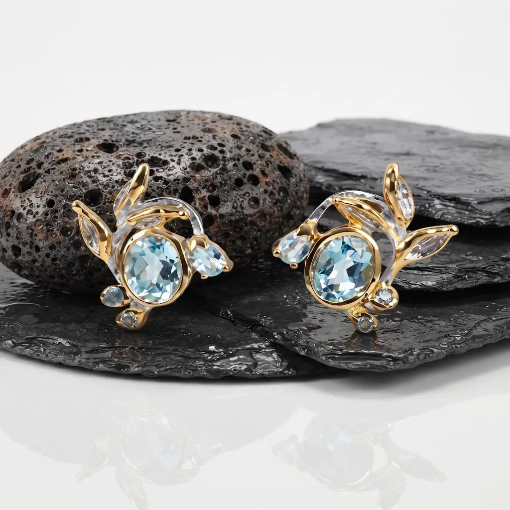 René Rose Jewelry AZURE ÉCLAT Ohrstecker mit blauem Topas und Saphiren aus 925 Sterling Silber, mit Rhodium- und 22 Karat Gelbgoldbeschichtung, präsentiert auf Lavastein mit Schieferplatten