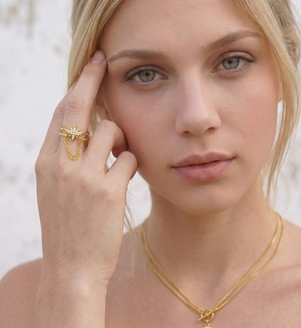 Aria – Goldener Ring mit Polarstern Motiv und Kristallsteinen getragen an der Hand von René Rose Jewelry