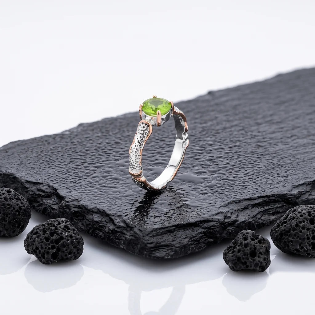 LIVIA BOTANICA – Filigraner Bicolor Ring mit grünem Peridot Edelstein aus 925 Sterling Silber präsentiert auf schwarzem Lavastein von René Rose Jewelry