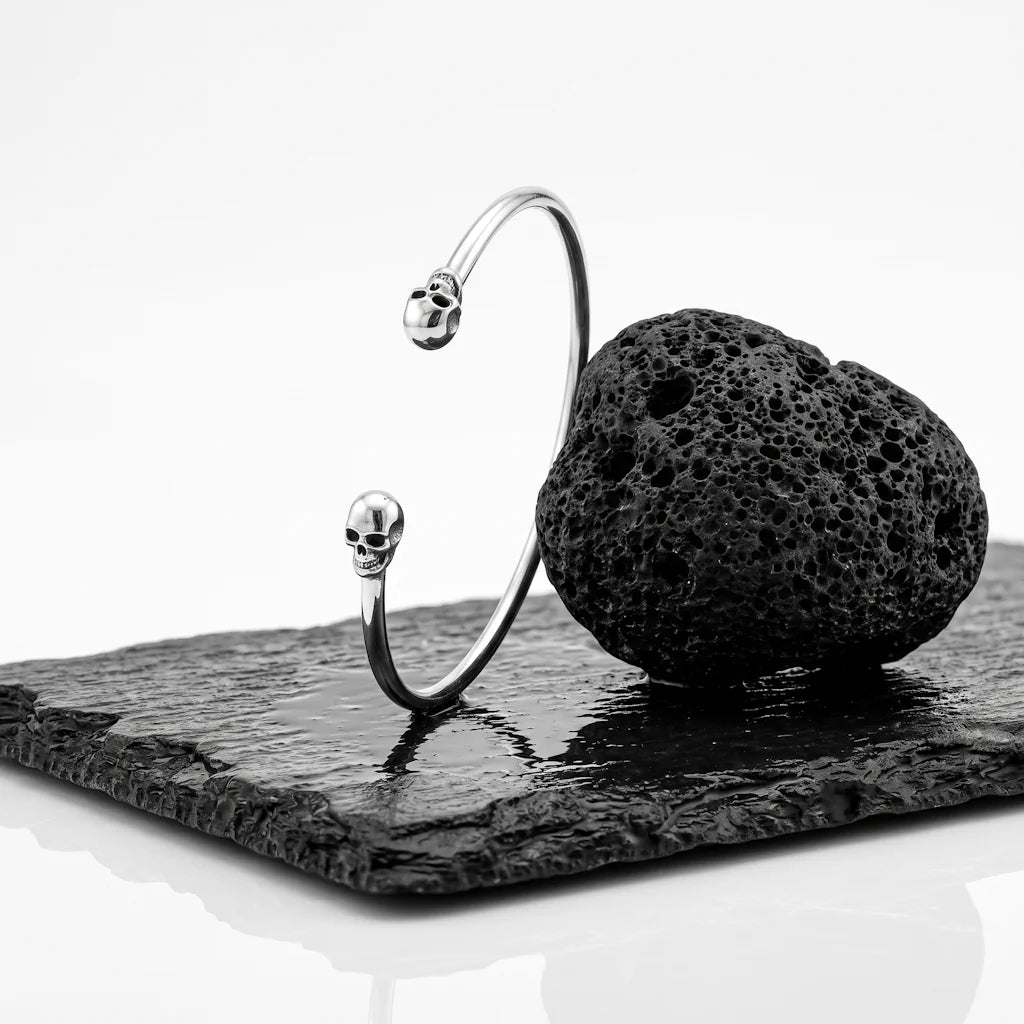 VISKA SKULL – Breiter Totenkopf Manschetten Armreif aus massivem 925 Sterling Silber präsentiert auf schwarzem Lavastein von René Rose Jewelry