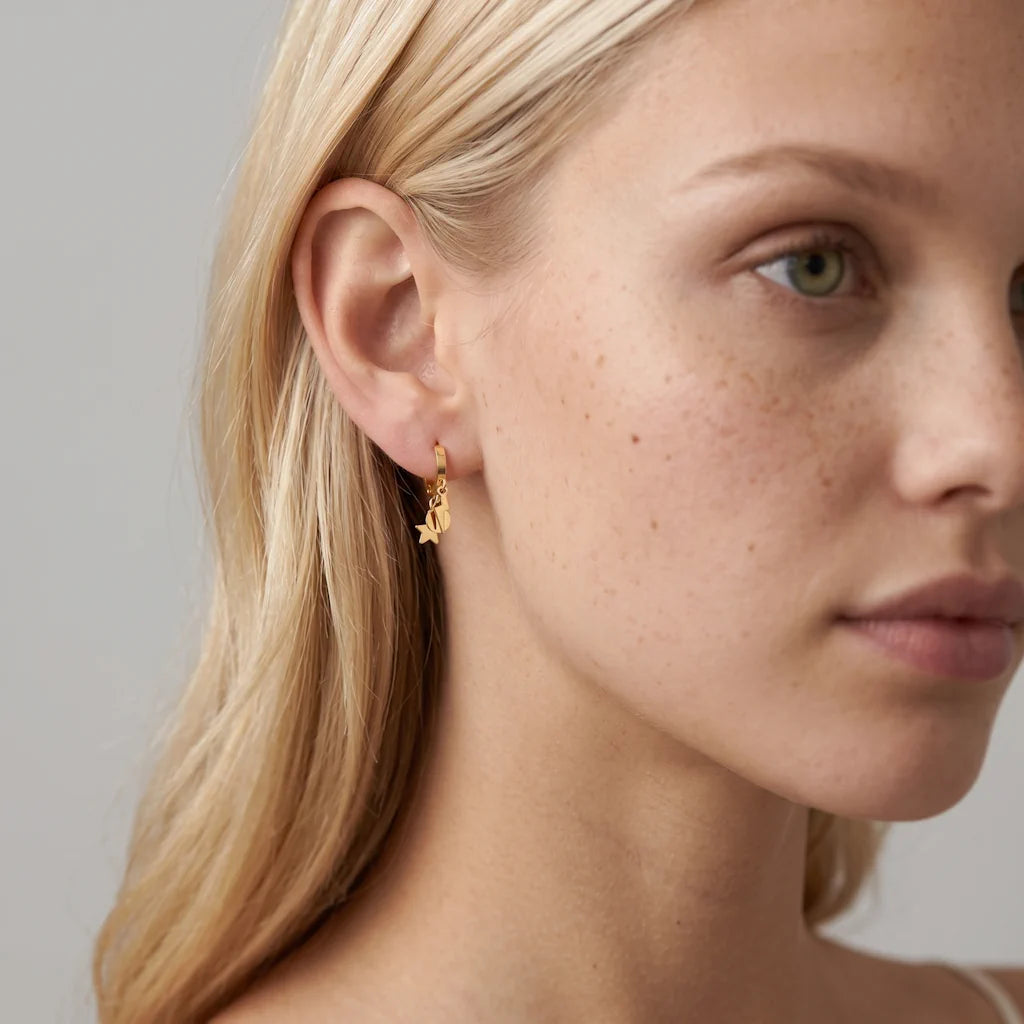 JULIETA STELLA – Filigrane goldene Ohrringe mit Stern Anhänger im Astral Design getragen am Ohr von René Rose Jewelry