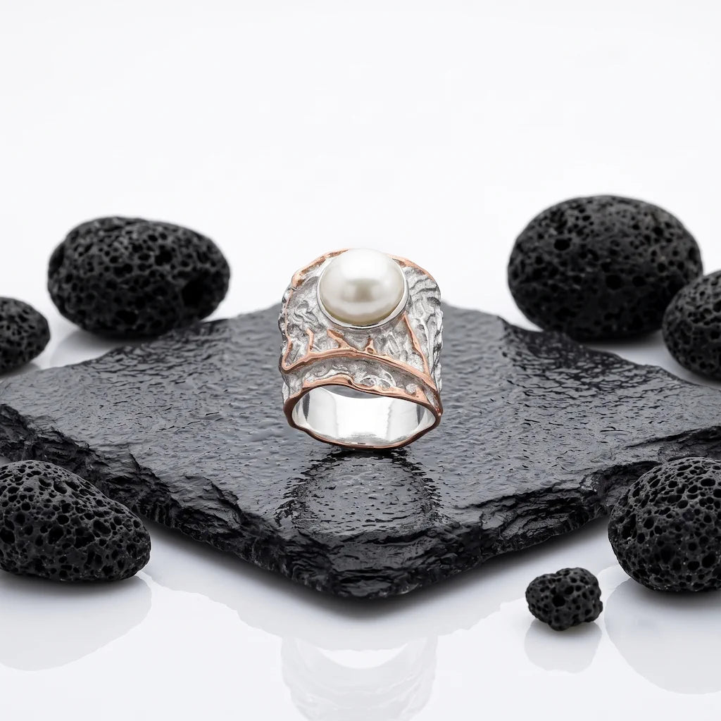 REGINA PERLA – Breiter Bicolor Statement Ring mit echter Perle aus 925 Sterling Silber präsentiert auf schwarzem Lavastein von René Rose Jewelry