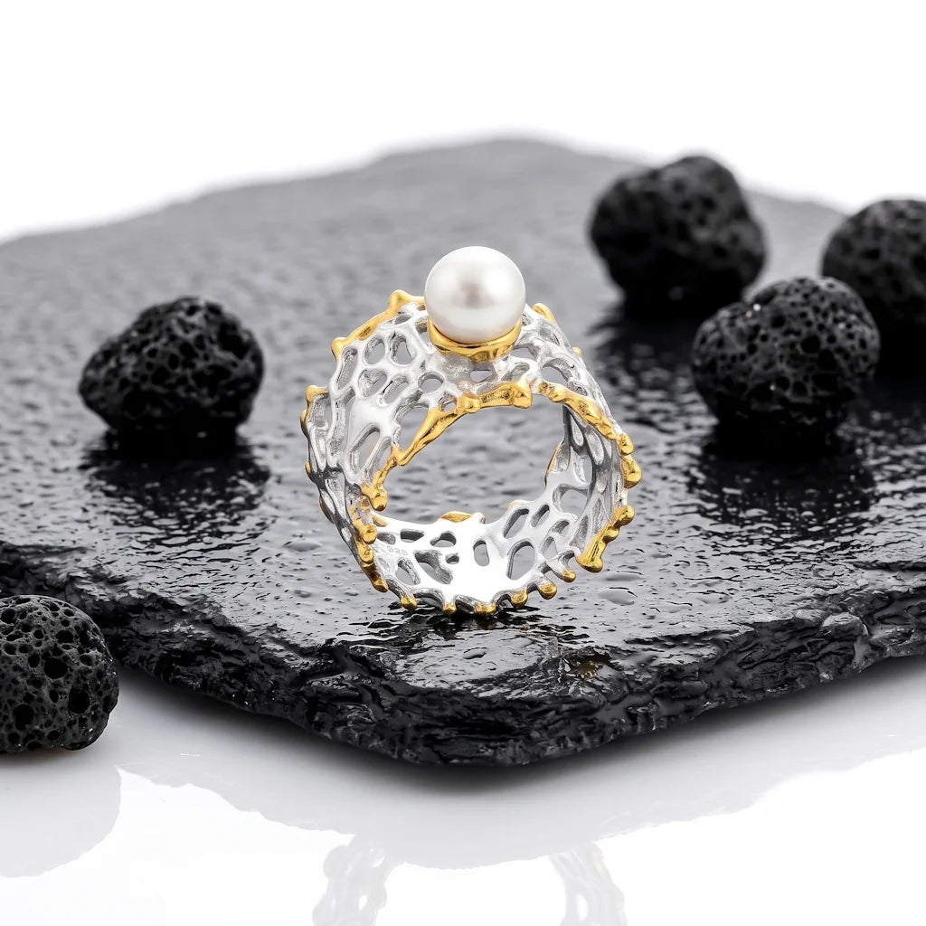 OANA REEF – Breiter Bicolor Statement Ring mit echter Perle aus 925 Sterling Silber präsentiert auf schwarzem Lavastein von René Rose Jewelry