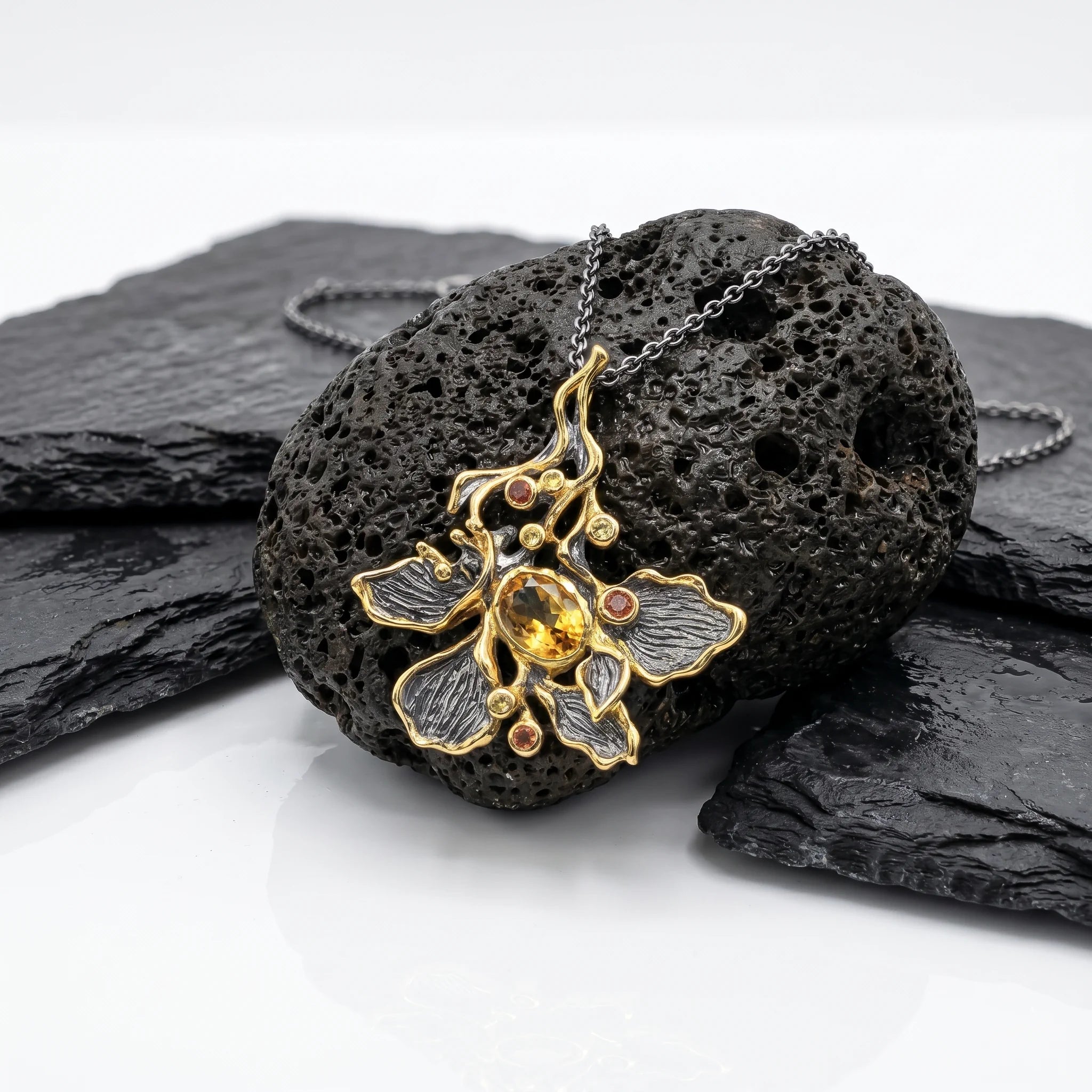 ORCHIDÉE SOLARE – Exklusive Orchideen Kette aus 925 Sterling Silber mit Bicolor Vergoldung präsentiert auf schwarzem Lavastein von René Rose Jewelry