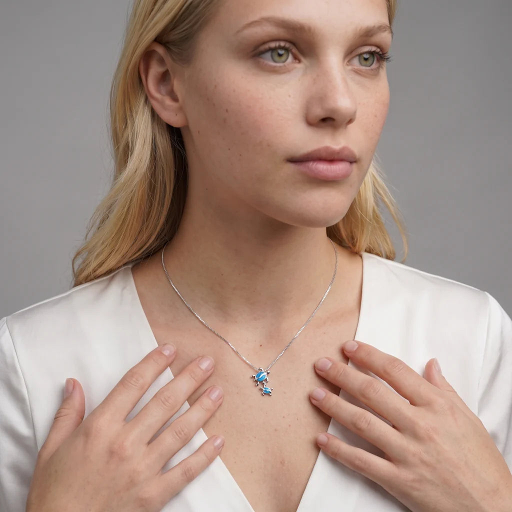 SCHILLY COELUM – Elegante silberne Halskette mit Schildkröten Motiv als Familie Talisman getragen am Dekolleté von René Rose Jewelry