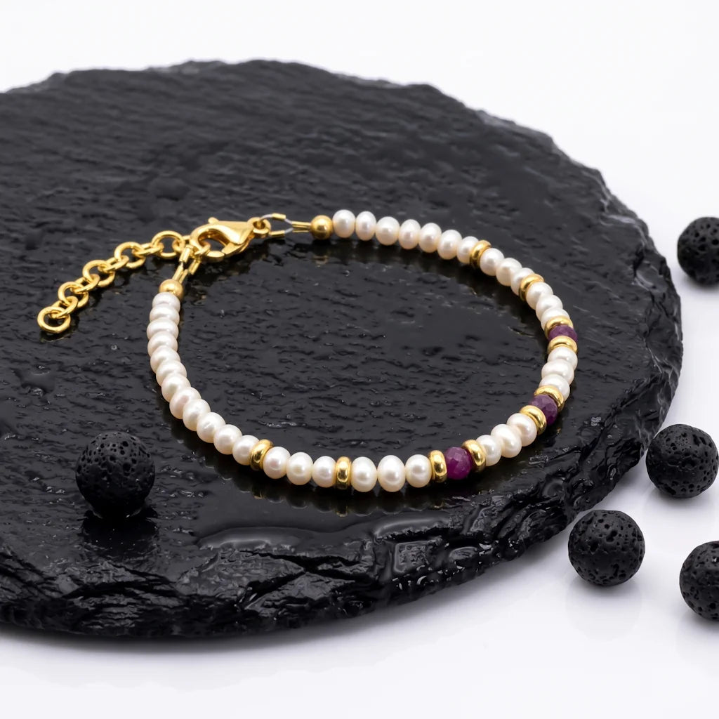 KATIA RUBY – Exklusives Perlenarmband mit rotem Rubin aus 18k vergoldetem 925 Sterling Silber präsentiert auf dunkler Schieferplatte von René Rose Jewelry