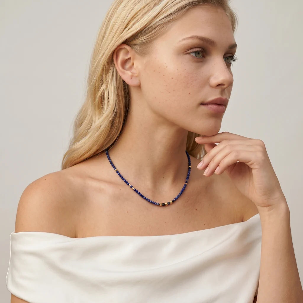 JUANA LAPIS – Elegantes goldenes Collier mit blauem Naturstein getragen am Dekolleté von René Rose Jewelry