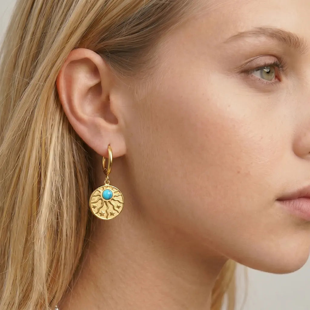 MEDAILLON SOLARE – Elegante Medaillon Ohrringe mit 18k Vergoldung und Sonnen Motiv getragen am Ohr von René Rose Jewelry