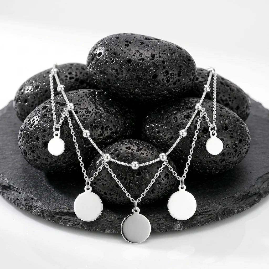 LUNA FESTIVAL – Exklusive Chandelier Kette mit schwingenden Medaillons aus 925 Sterling Silber präsentiert auf dunkler Schieferplatte von René Rose Jewelry