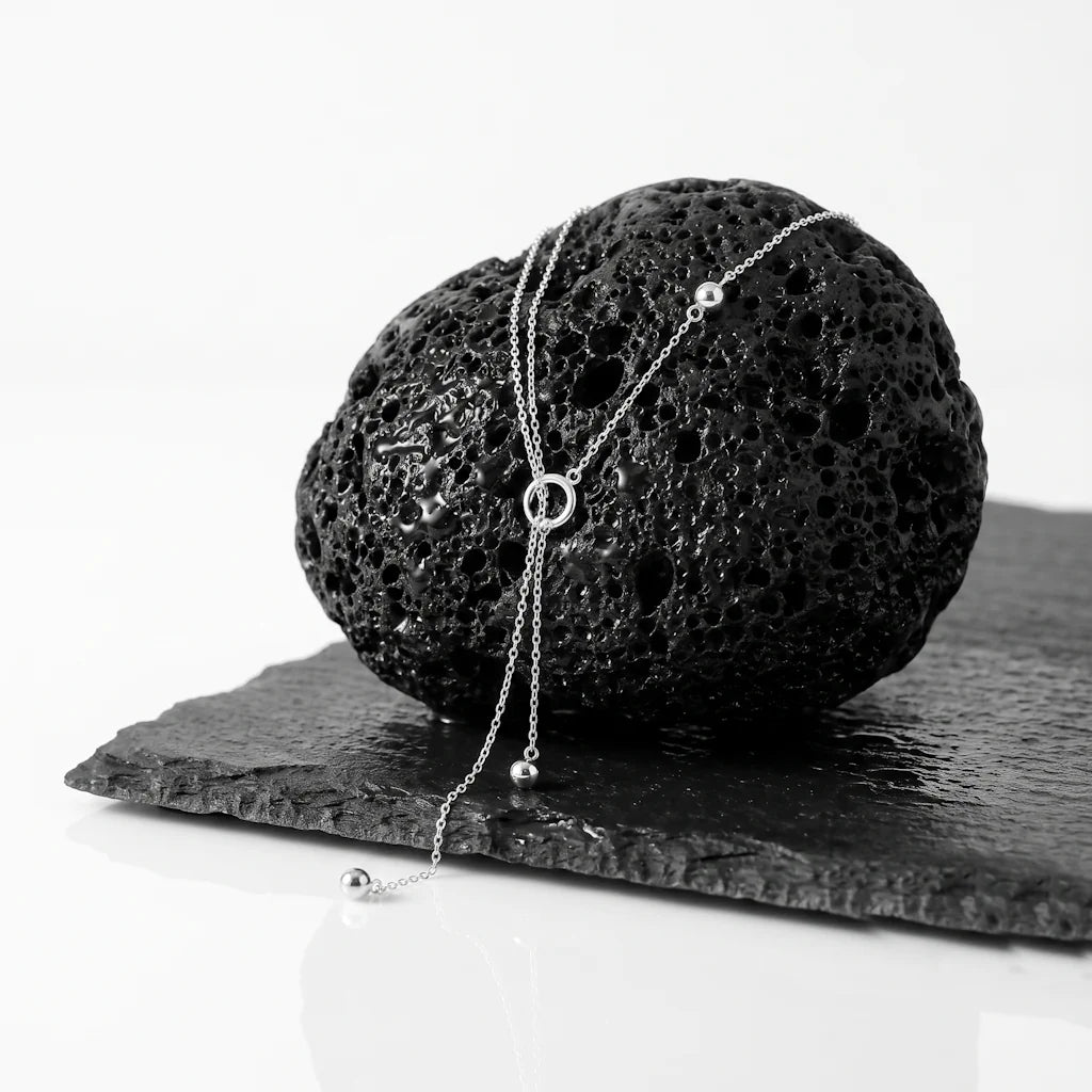 LUNA SPHERE – Zweireihige Y Kette mit silbernen Kugel Anhängern aus 925 Sterling Silber präsentiert auf dunkler Schieferplatte von René Rose Jewelry