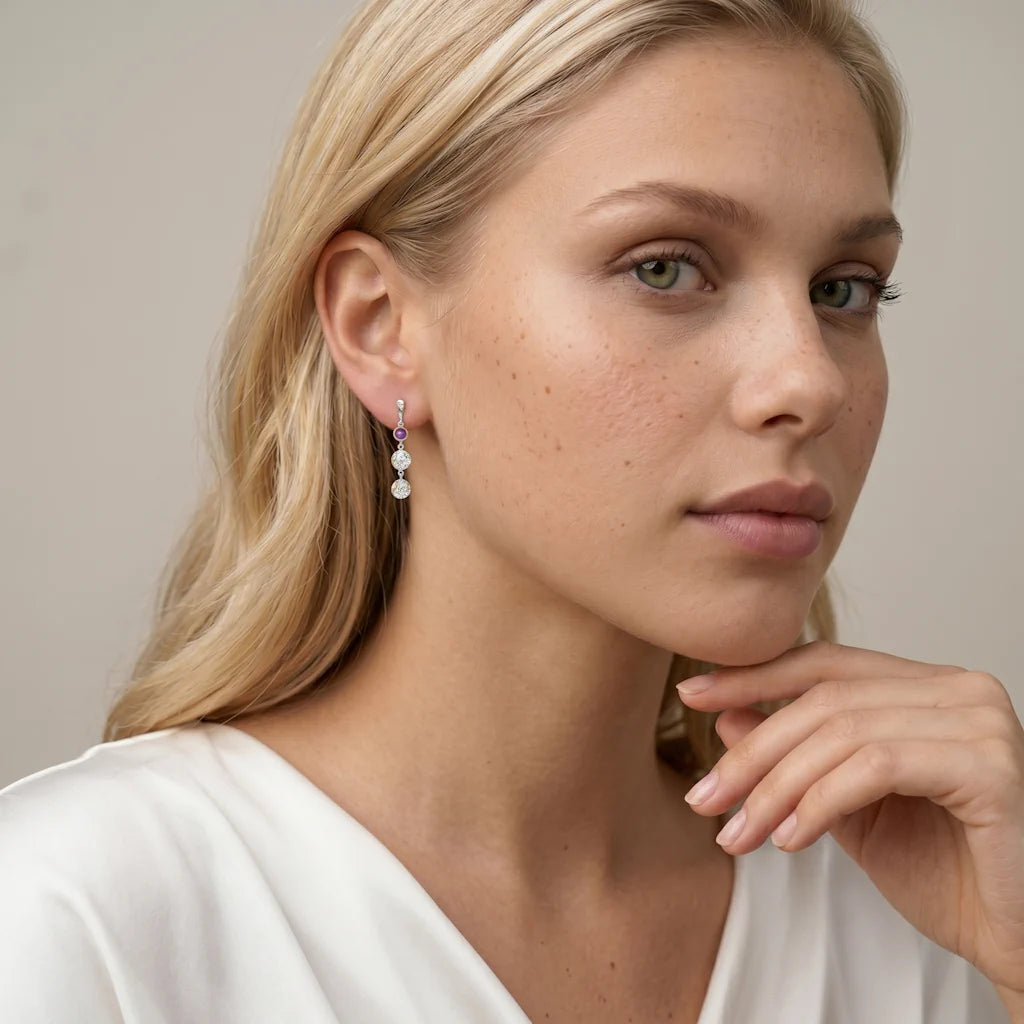 OANA MYSTIQUE – Lange goldene Statement Ohrringe mit lila Stein getragen am Ohr von René Rose Jewelry