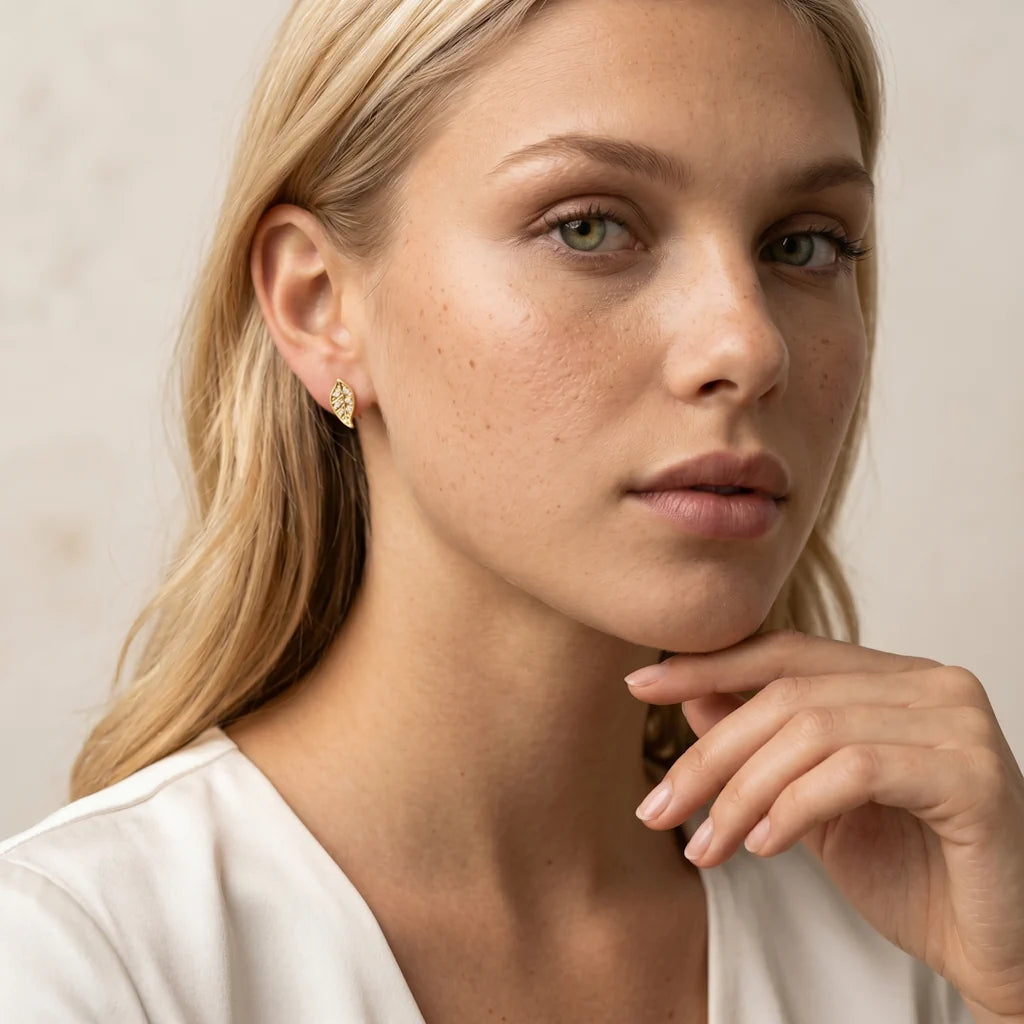 FOGLIA TRAFORATA – Kleine goldene Ohrstecker mit feinem Blätter Motiv getragen am Ohr von René Rose Jewelry