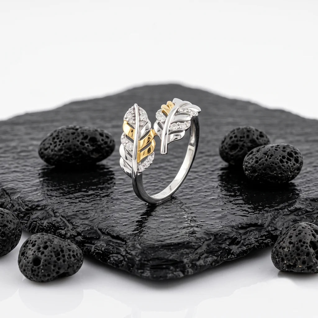 ALICE PIUMA – Exklusiver Feder Ring im Bypass Design aus 925 Sterling Silber präsentiert auf schwarzem Lavastein von René Rose Jewelry