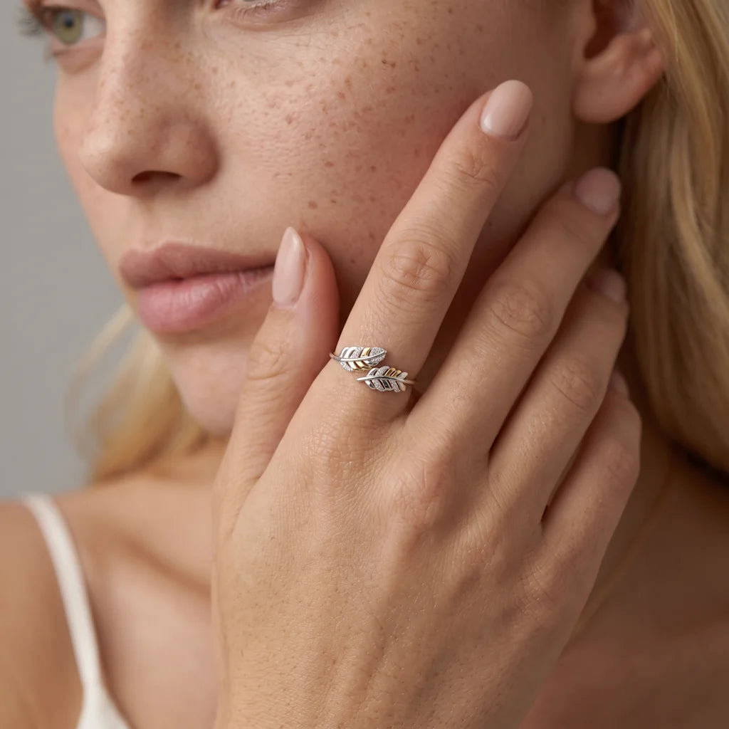 ALICE PIUMA – Opulenter goldener Ring mit funkelndem Feder Motiv getragen an der Hand von René Rose Jewelry