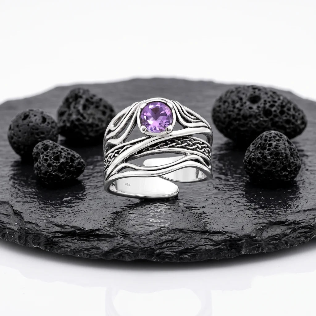 SUNNIVA AMETHYST – Breiter keltischer Ring mit lila Amethyst Edelstein aus 925 Sterling Silber präsentiert auf schwarzem Lavastein von René Rose Jewelry