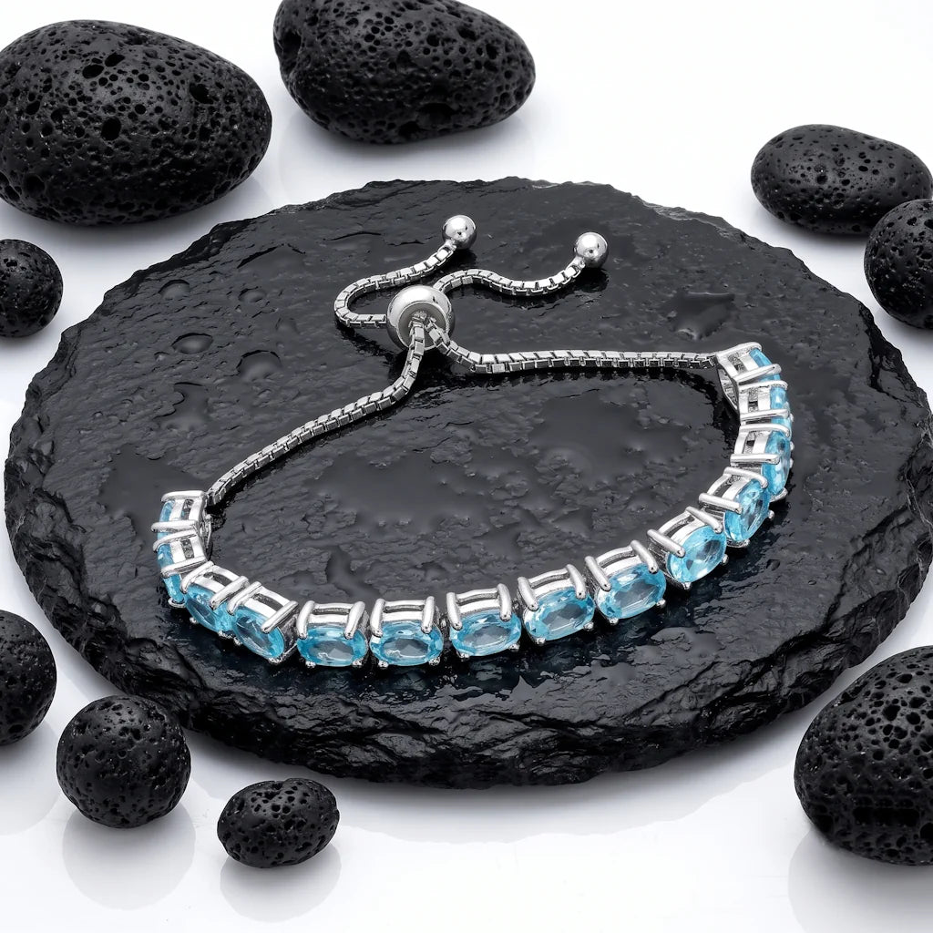 ISHANI TOPAZ – Filigranes Tennisarmband mit hellem Topas Edelstein aus rhodiniertem 925 Sterling Silber präsentiert auf dunkler Schieferplatte von René Rose Jewelry