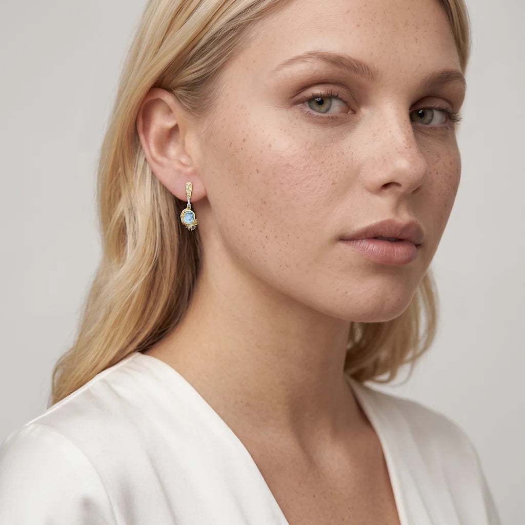 ASTRAL REEF – Opulente goldene Ohrhänger im maritimen Korallen Design mit blauen Edelsteinen getragen am Ohr von René Rose Jewelry