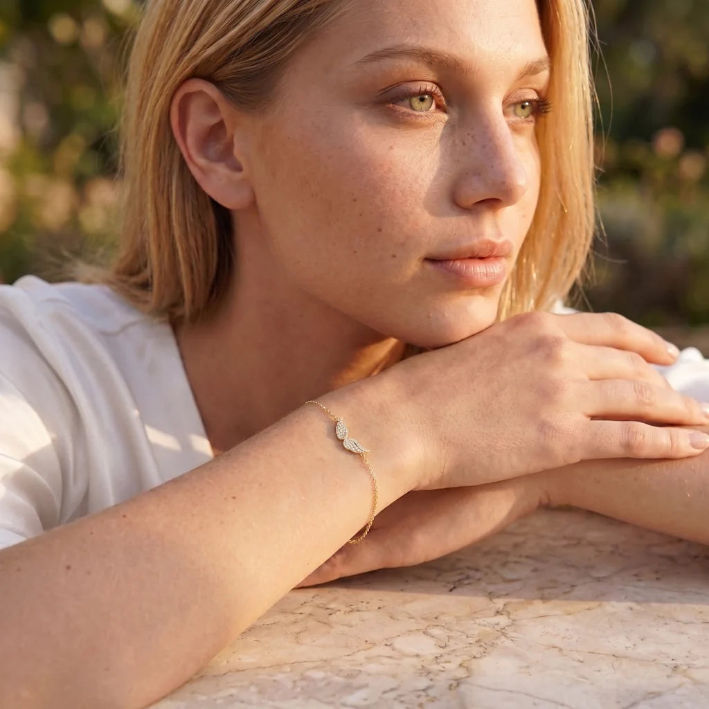 Model trägt das René Rose Jewelry CELESTIA Designer-Armband aus 925 Sterling Silber mit Engelsflügeln, weißen Zirkonia und hochwertiger 14 Karat Gelbgold- oder Roségold-Vergoldung.
