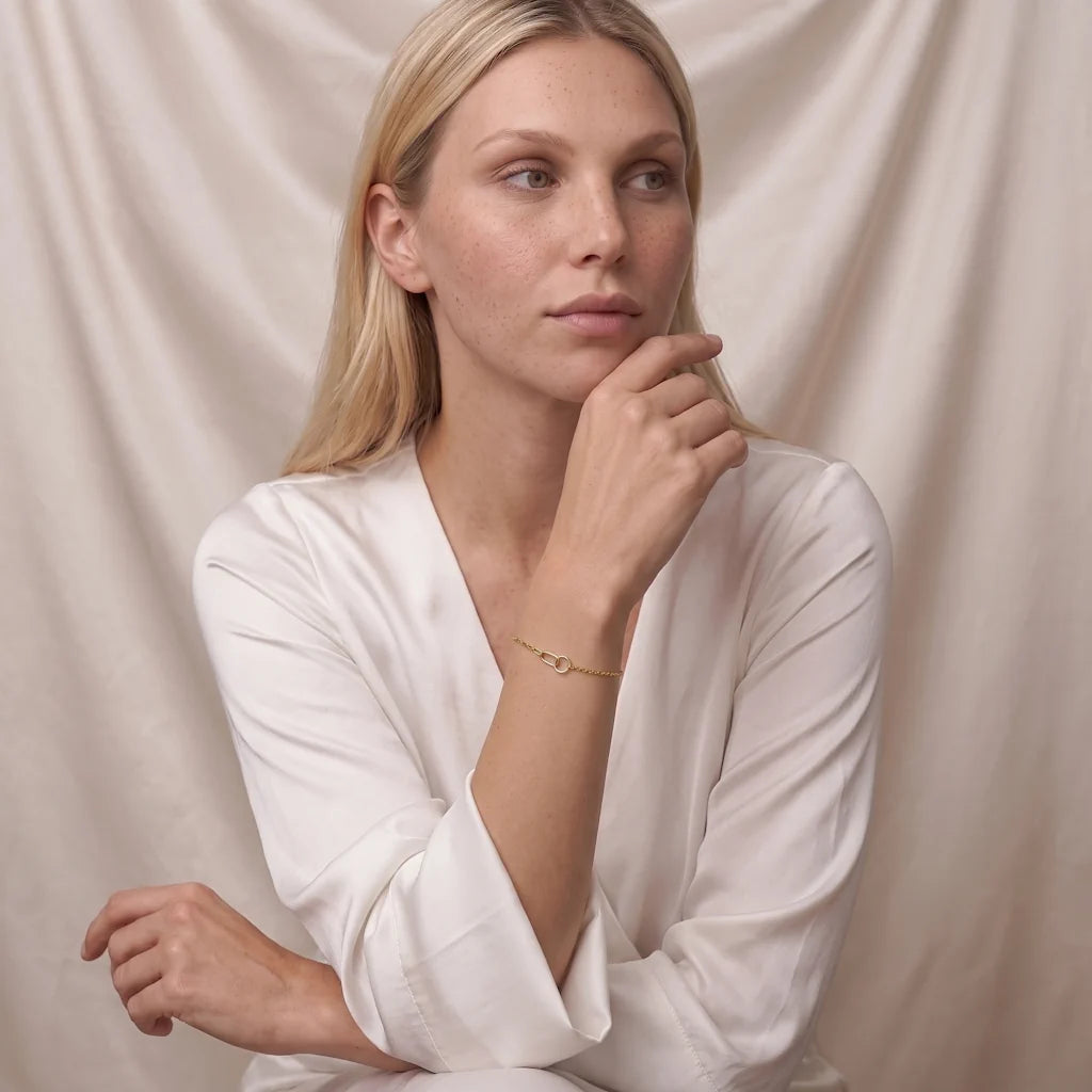Model trägt das René Rose Jewelry ÉLIANE Designer-Armband aus 925 Sterling Silber mit Kreis, Oval, doppelreihiger Gliederkette und hochwertiger 14 Karat Gelbgold-Vergoldung.