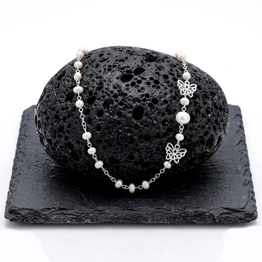 PAPILLON ASYMMÉTRIE – Exklusive Schmetterling Perlenkette aus 925 Sterling Silber präsentiert auf schwarzem Lavastein von René Rose Jewelry