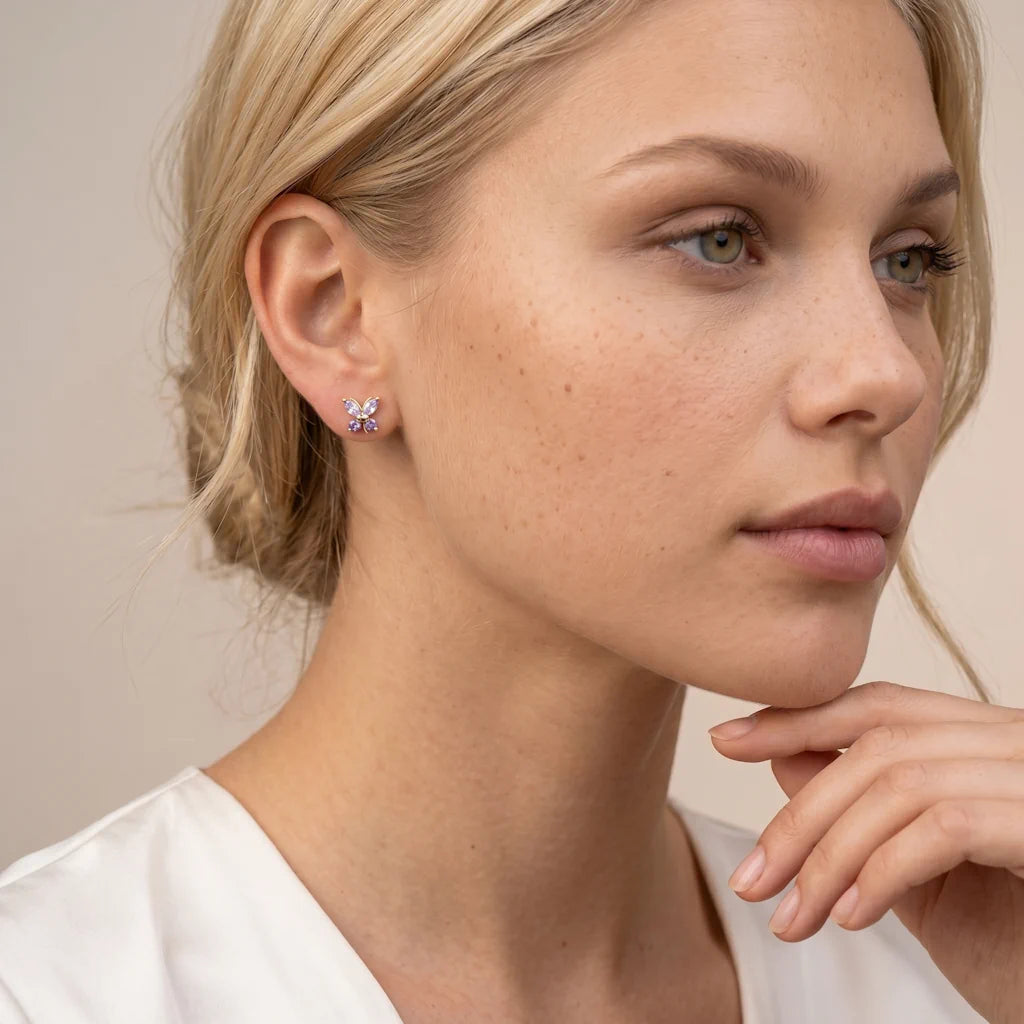 FARFALLA VIOLA – Kleine goldene Schmetterlings Ohrstecker mit farbigen Steinen getragen am Ohr von René Rose Jewelry